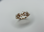 Angled view of the unique butterfly fashion ring catching studio light to emphasize the gleam of the pearls and high-polish gold.